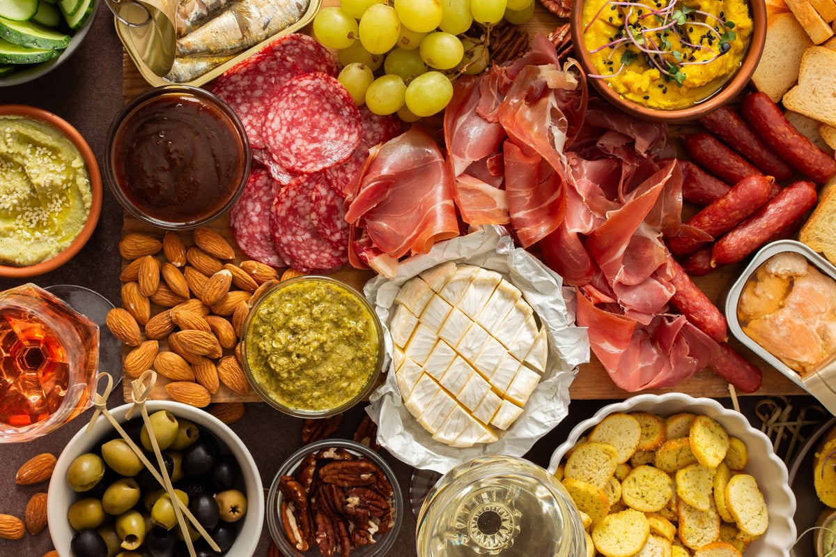 Abundant charcuterie spread with cheese, sausages and fresh sandwiches